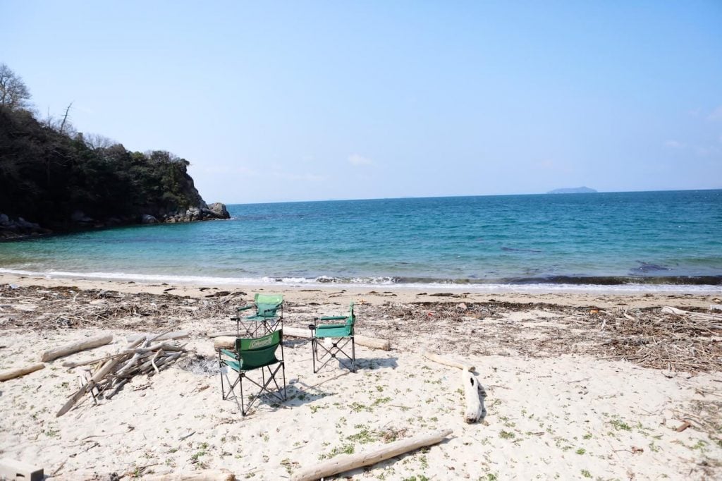 写真:きれいな海岸と3脚のいす