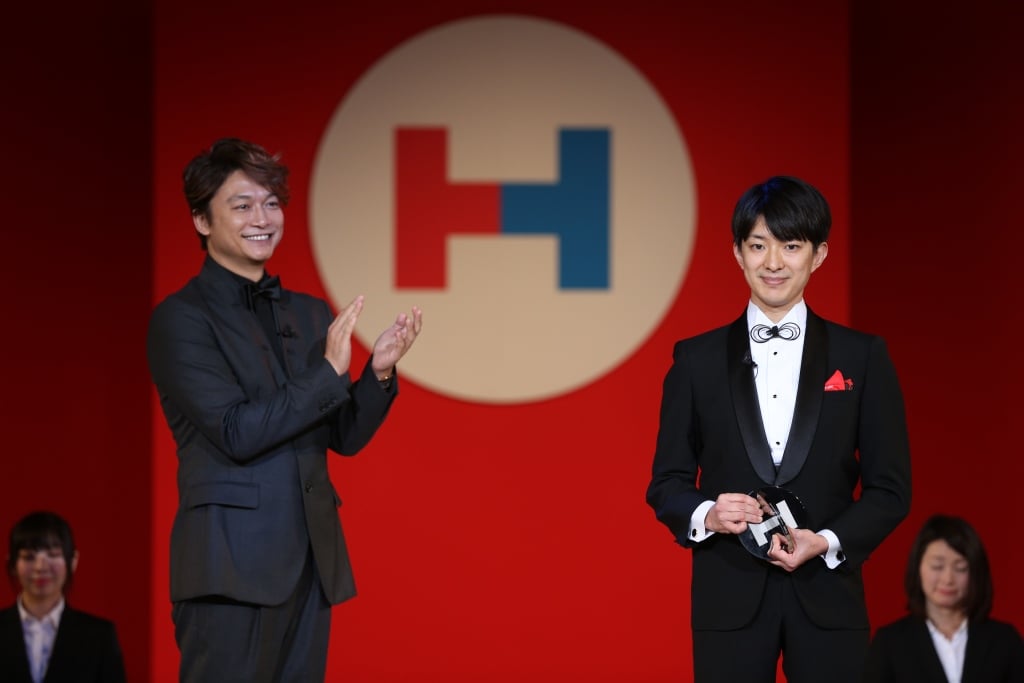 写真:「HEROs AWARD 2017」を受賞し、タレントの香取慎吾さんから拍手を送られ、微笑む澤田さん