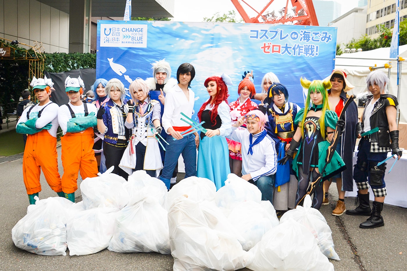 写真:2,700リットルのごみが入ったごみ袋の前に並ぶ世界を代表するコスプレイヤーたち