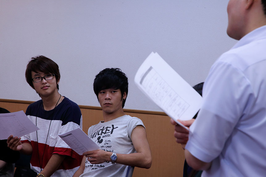 写真：事務局職員の話を聞く奨学生
