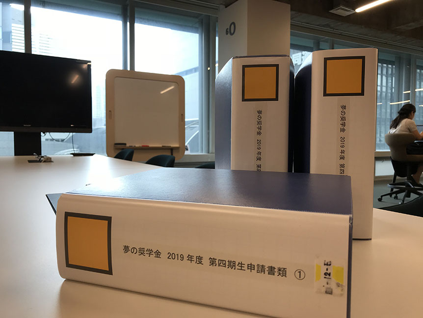 写真：分厚い申請書のバインダー3つ