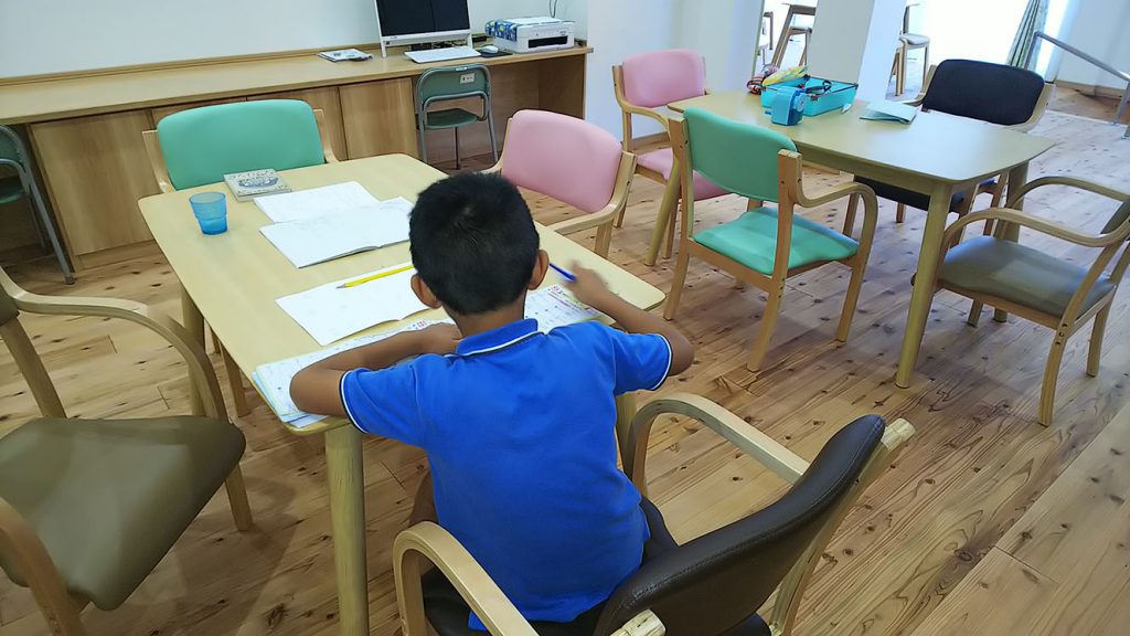 写真:自由な広場で勉強する男の子