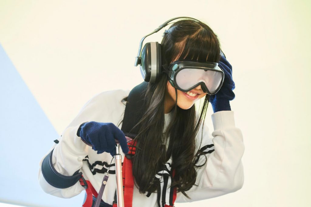 写真:ゴーグルとヘッドホンなど高齢者体験キットを装着した祝さん