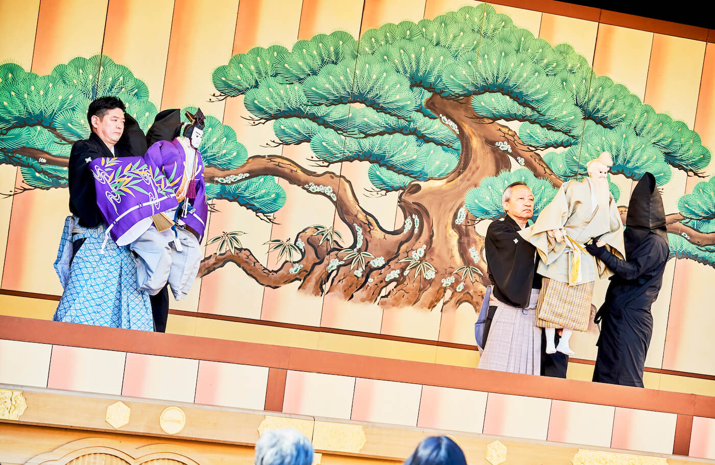 写真:舞台上で、三條小鍛冶宗近の人形を操る人形遣いたちと、老翁実の人形を操る人形遣いたち