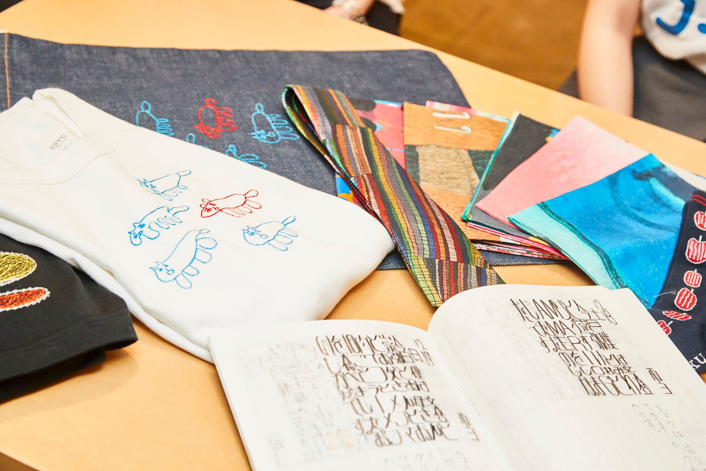 写真:MUKUで販売するTシャツ、ハンカチ、ネクタイ、カバンといったさまざまなアイテム