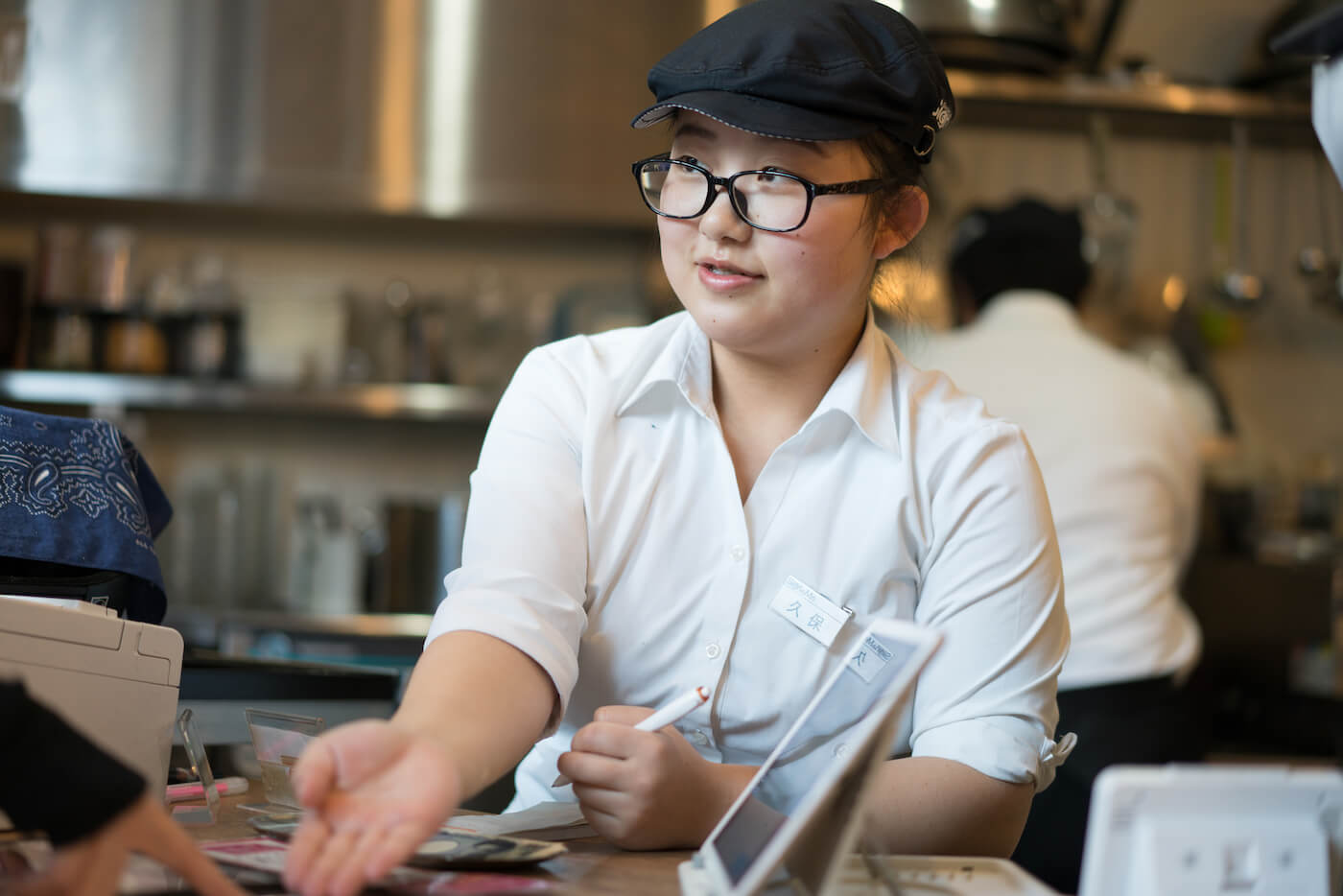 写真:メニューを指差すスタッフ