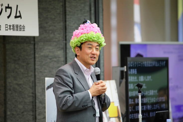 写真:被り物を頭につけた髙橋昭彦氏