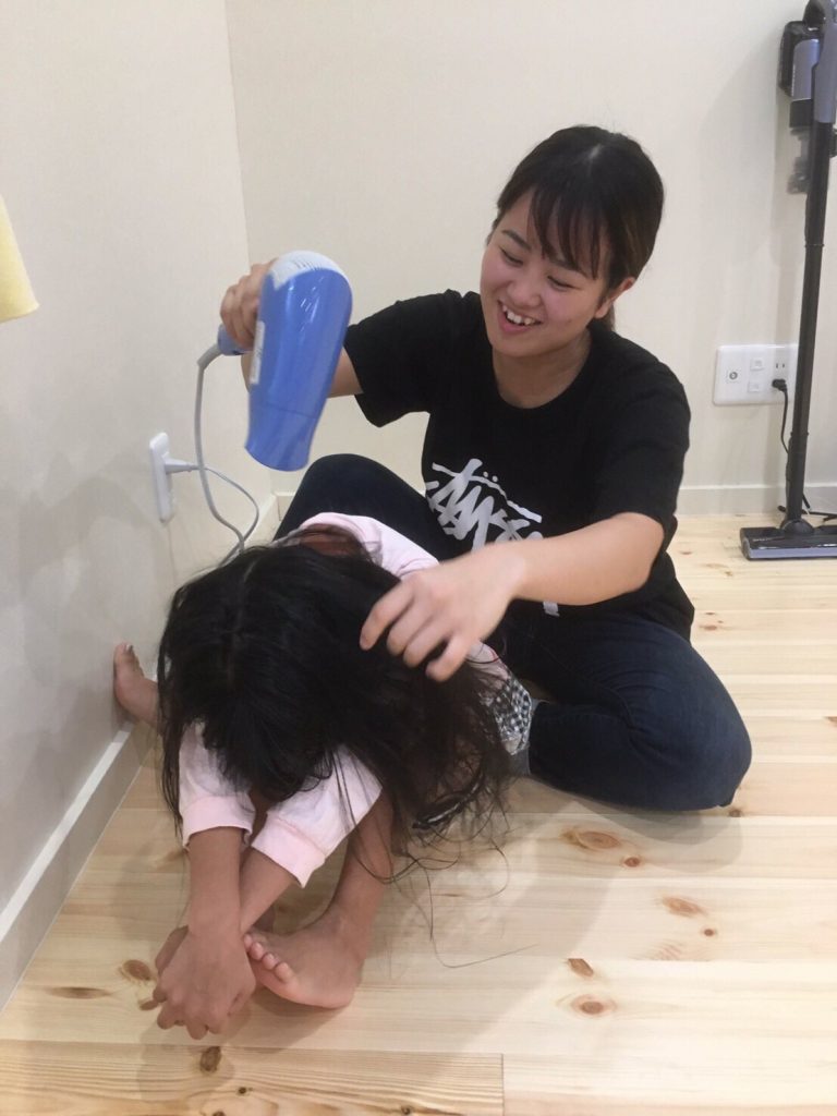 写真:スタッフに髪を乾かしてもらう子どもの様子