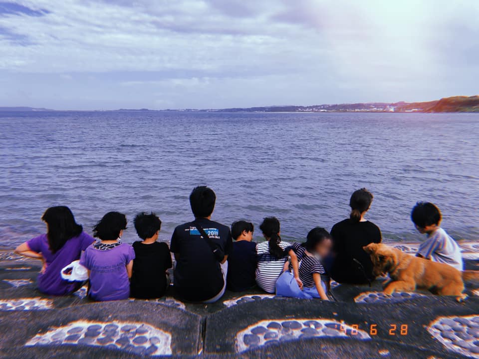 写真:海を眺める田場拠点のスタッフと子どもたち