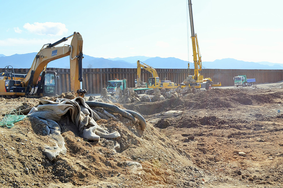写真:千曲川の堤防の決壊現場では、ショベルやクレーンによる復旧工事が行われていました。奥には被災後に設置した仮堤防が設置されていました