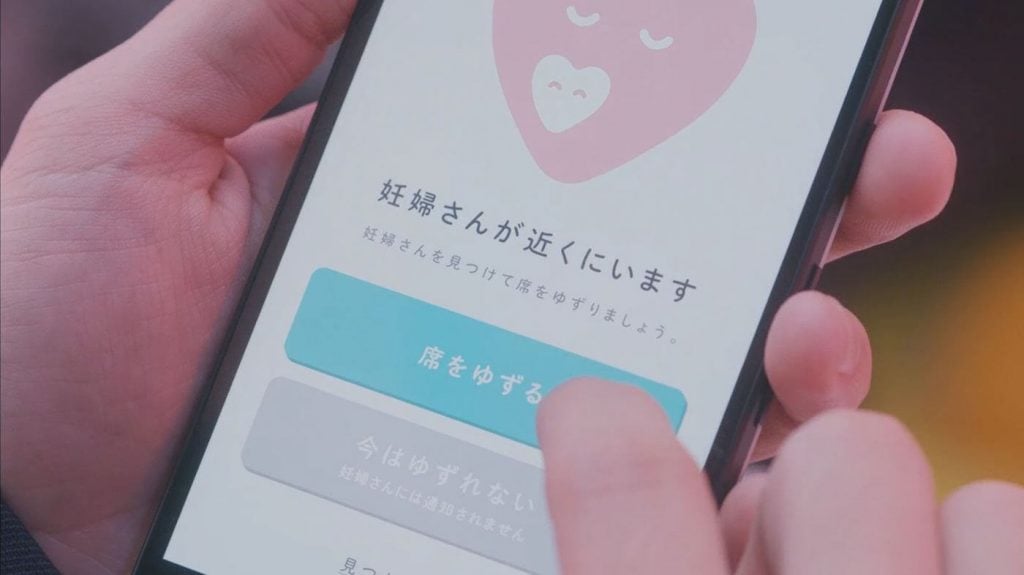 写真:「席をゆずる」ボタンを押すサポーター