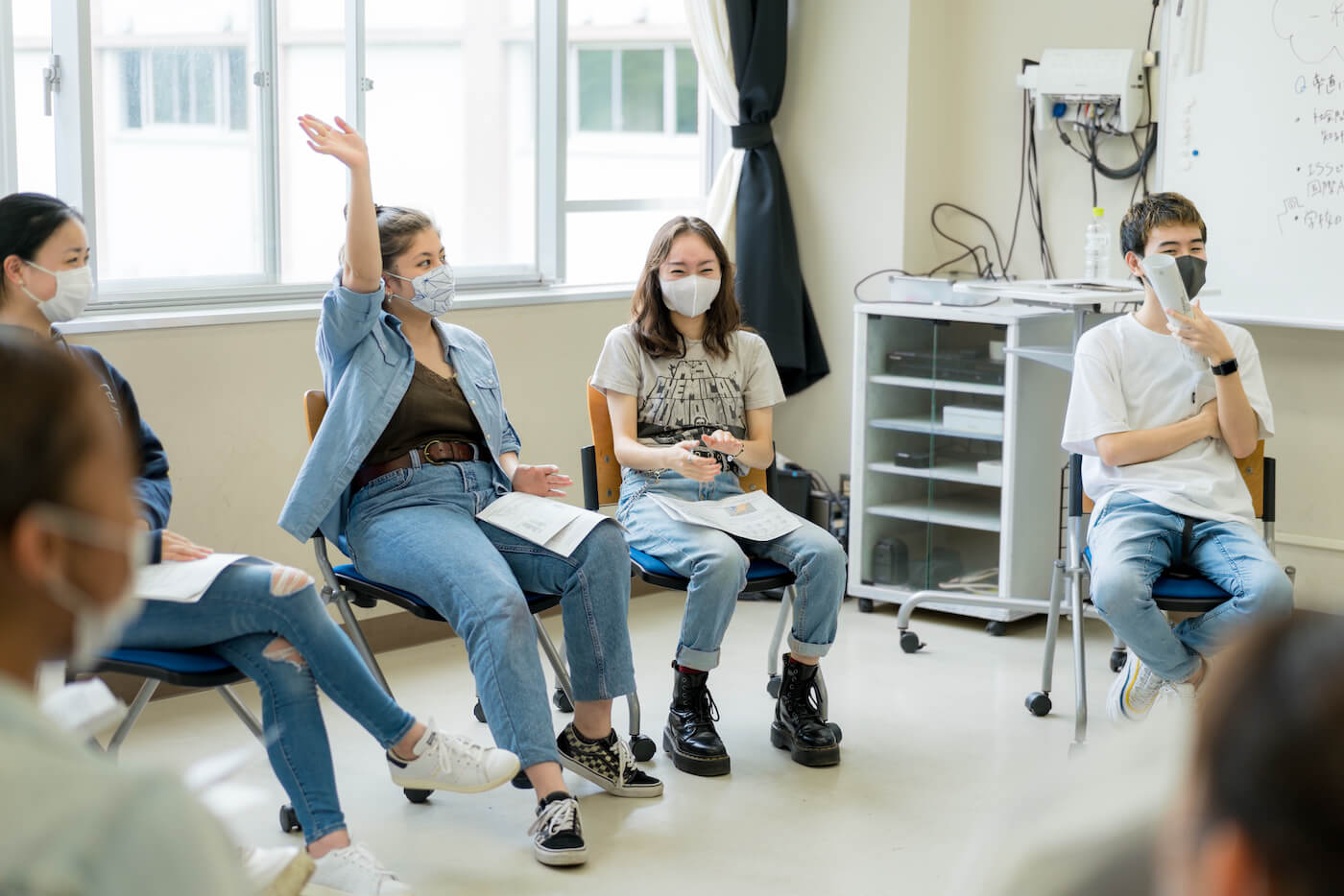 写真:手を上げて発言する高校生