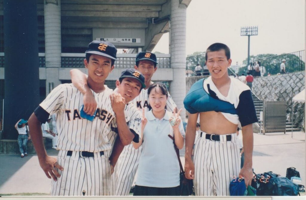写真:チームメートとマネージャーと一緒に記念撮影する野球少年だった時の三浦さん