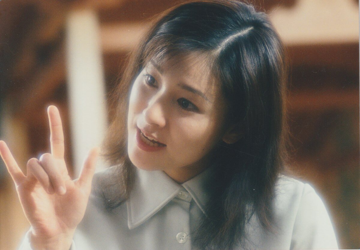 写真:手話で「アイ・ラヴ・ユー」を伝える忍足さん