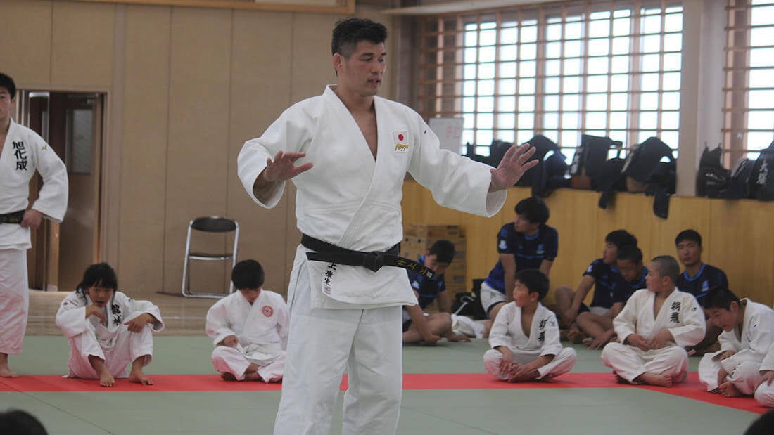 写真:柔道場で子どもたちに指導をする柔道着を着た井上康生さん