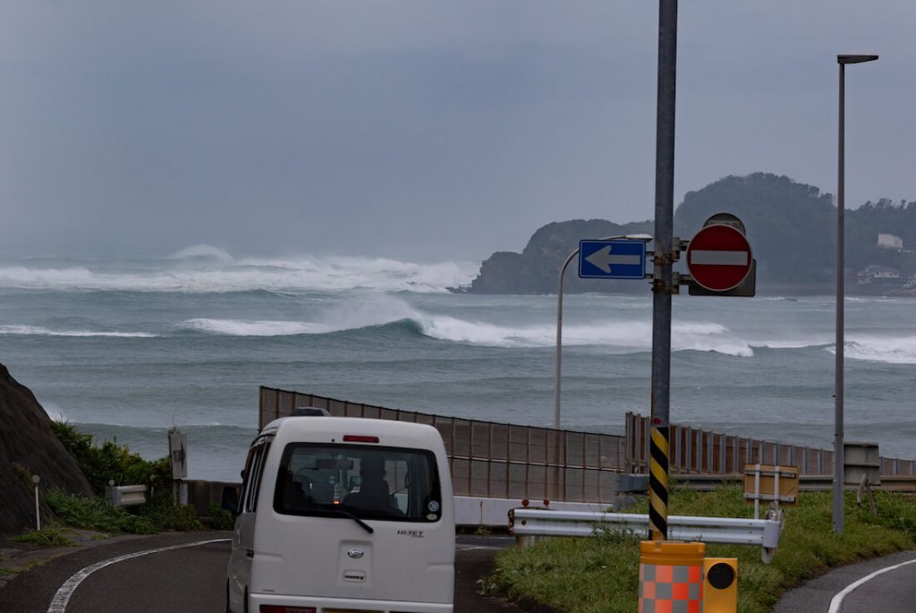 写真:高波の付近の道路を走る車