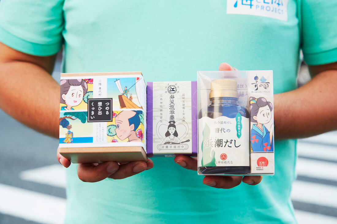 写真:「海ノ民話のまちプロジェクト」を機に開発されたコラボ商品を手に持つ沼田さん