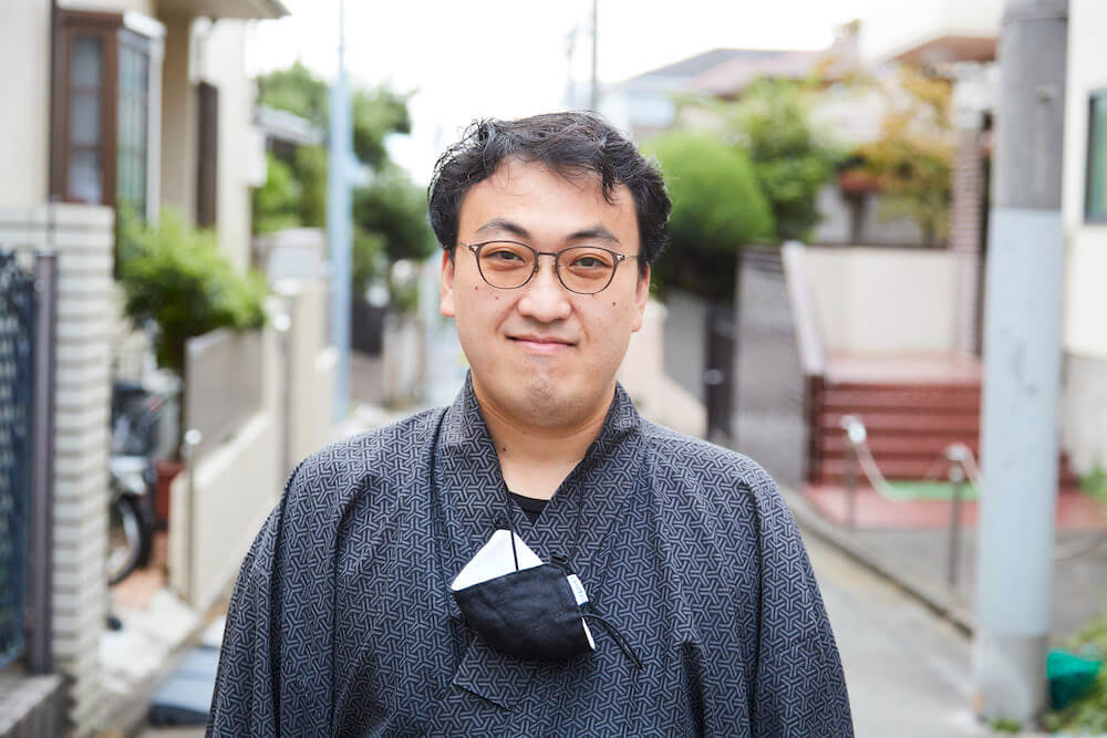 写真:路上でインタビューに応じる山口さん