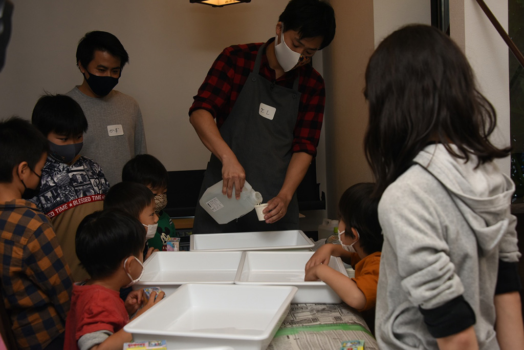 写真:マーブリングアートの作り方の説明を受ける子どもたちの様子