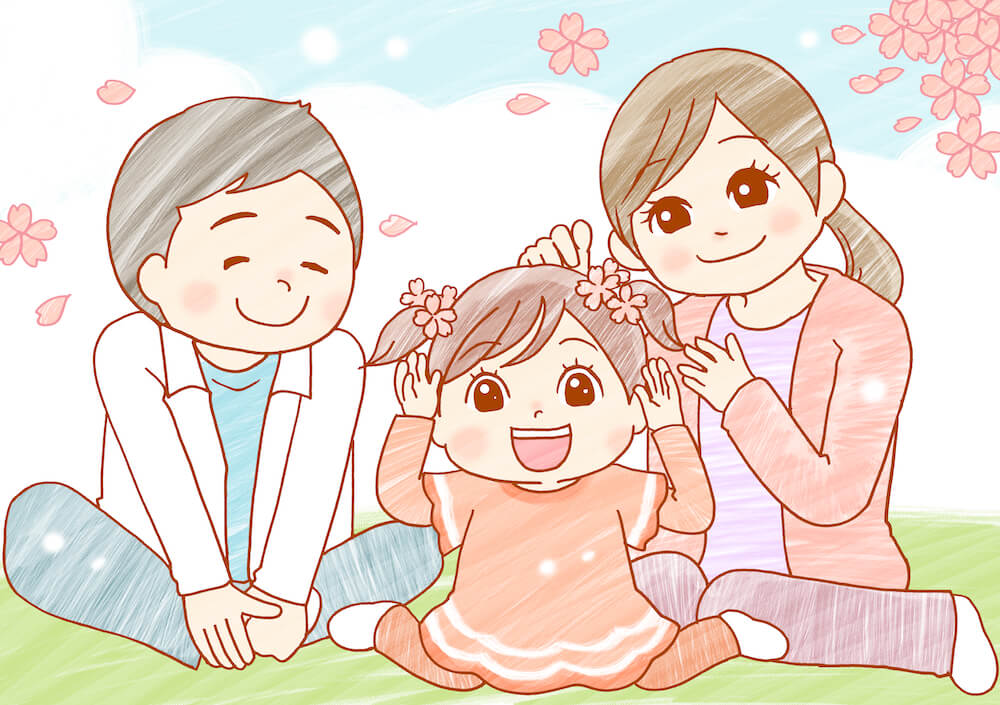 イラスト：草原に座る主人公の夫婦と真ん中に養子の女の子