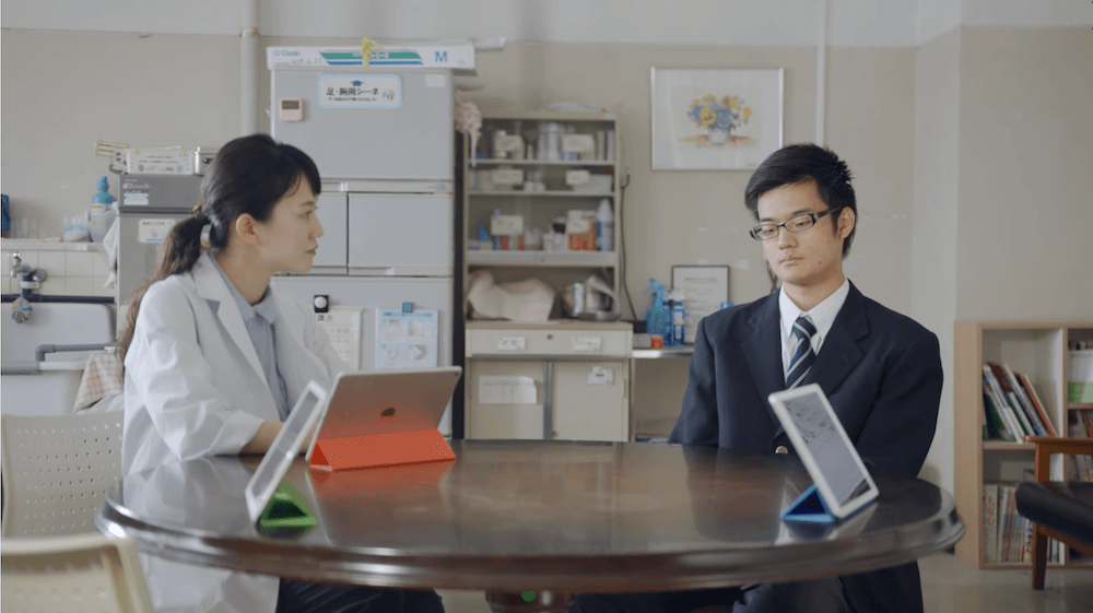 写真:回答結果をもとに生徒(右)に質問する養護教諭