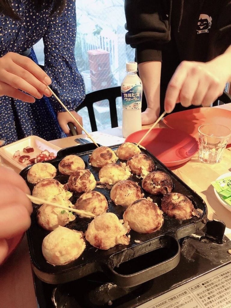 写真:たこ焼きを焼く、ヤングケアラーの子どもたち