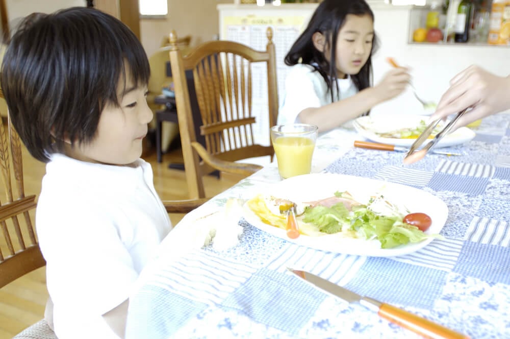 写真:こども食堂で一緒にごはんを食べる子どもたち