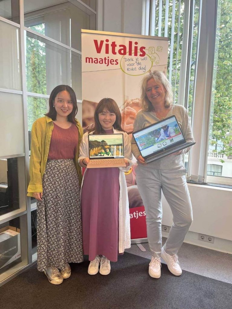 写真:Vitalis maatjesのメンバーと一緒に笑顔を向けるWe are Buddiesの加藤さんとメンバー