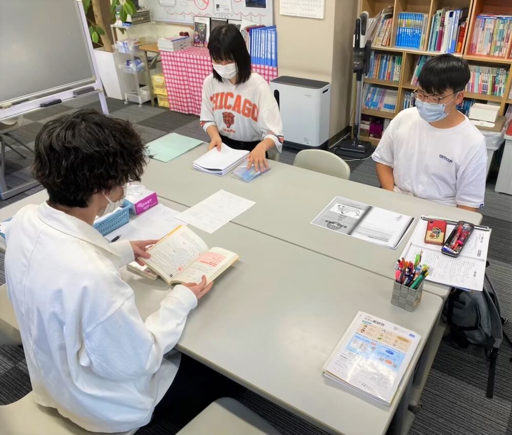 写真:
子ども第三の居場所で、学生スタッフに勉強を教えてもらう子どもたち