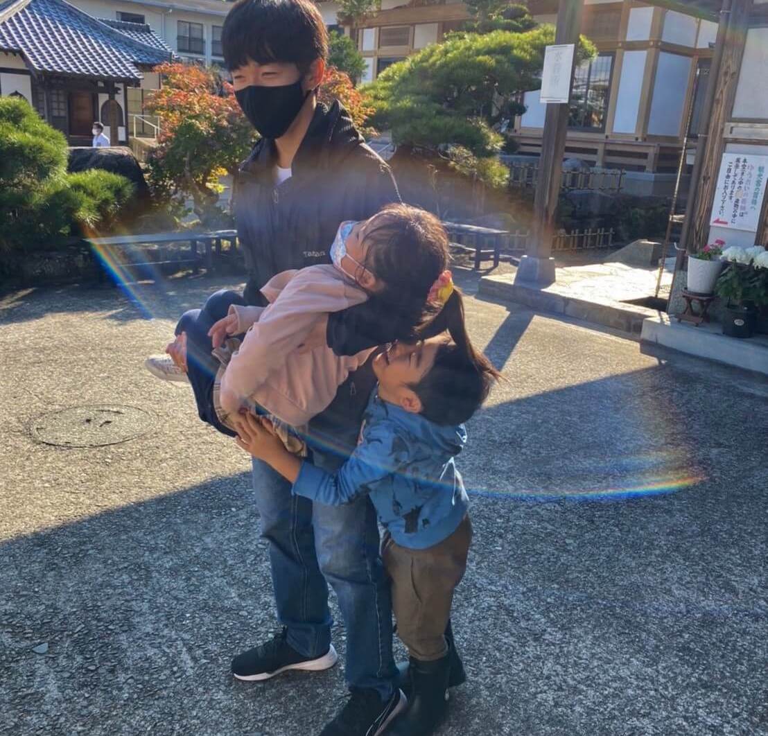 写真:外で学生スタッフと戯れる子どもたち