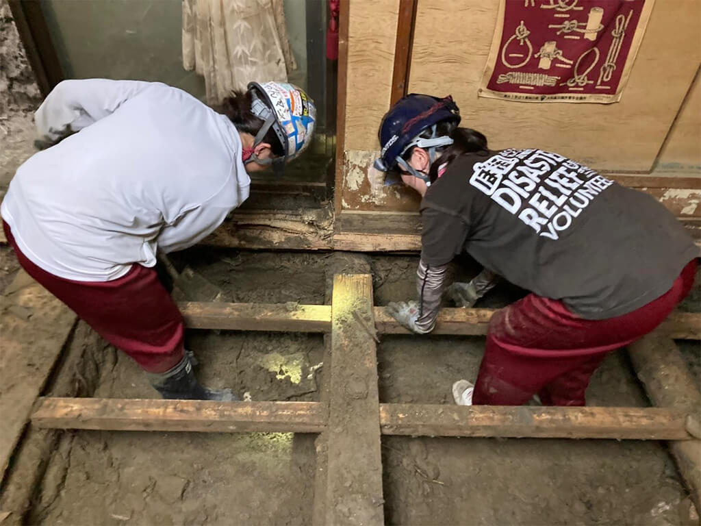 床下の土砂掻き出し作業をするボランティア