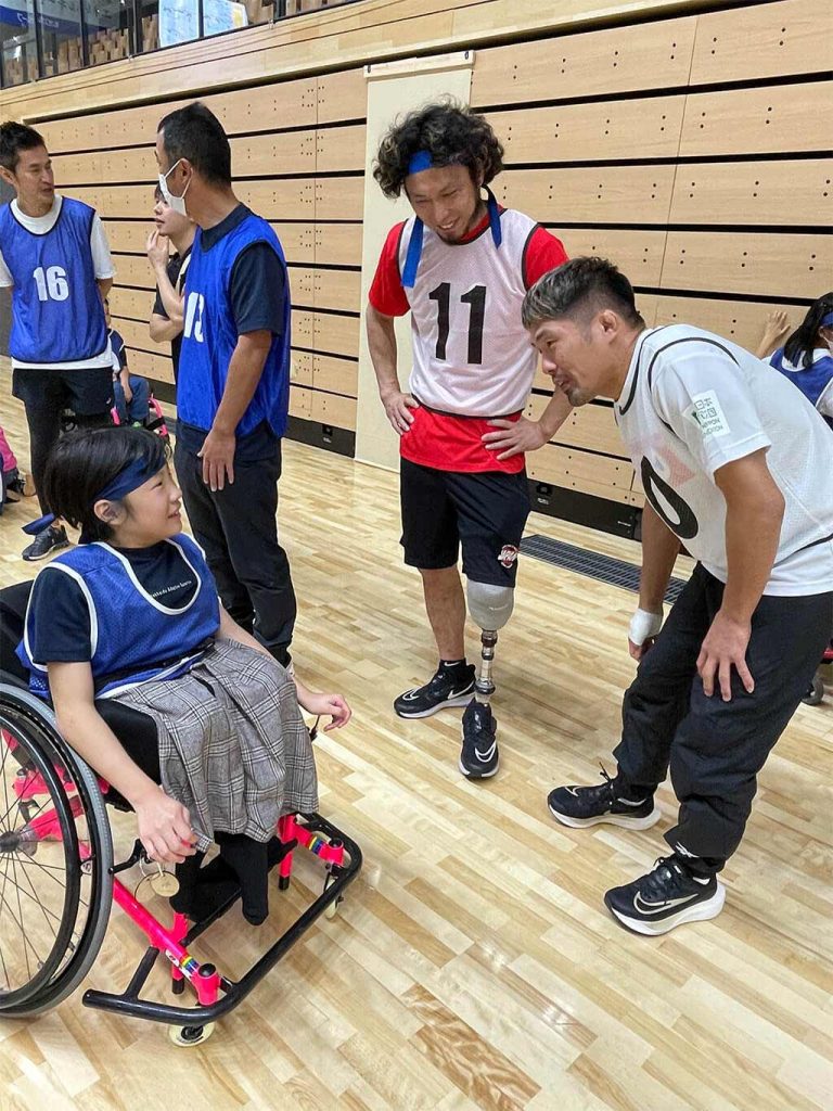 車いすに乗った少年と談笑する堀江航氏と川端龍氏