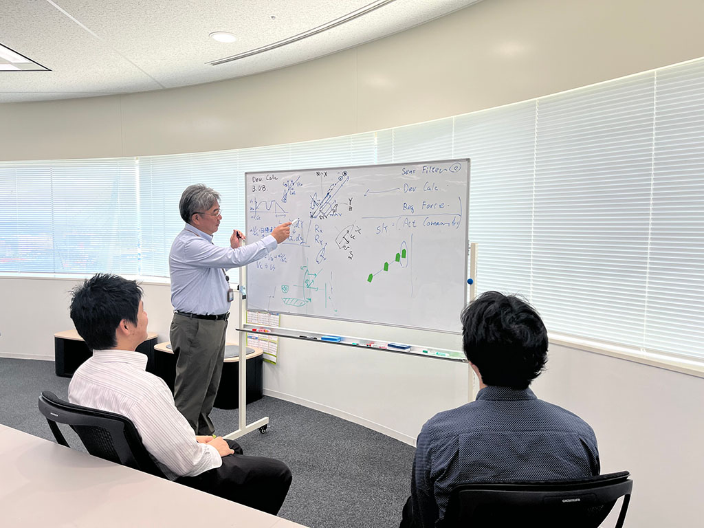 写真:新たに開発する操船制御システムのロジックについて、開発チームで議論している様子(三井E&S造船株式会社)