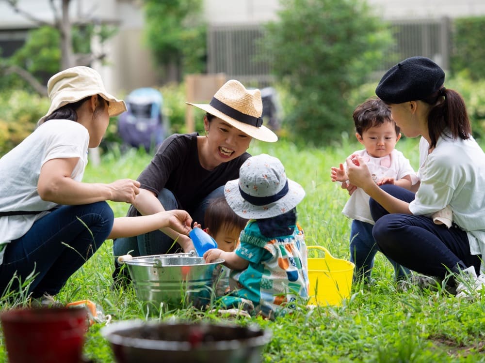 公園で土遊びをする母子たち