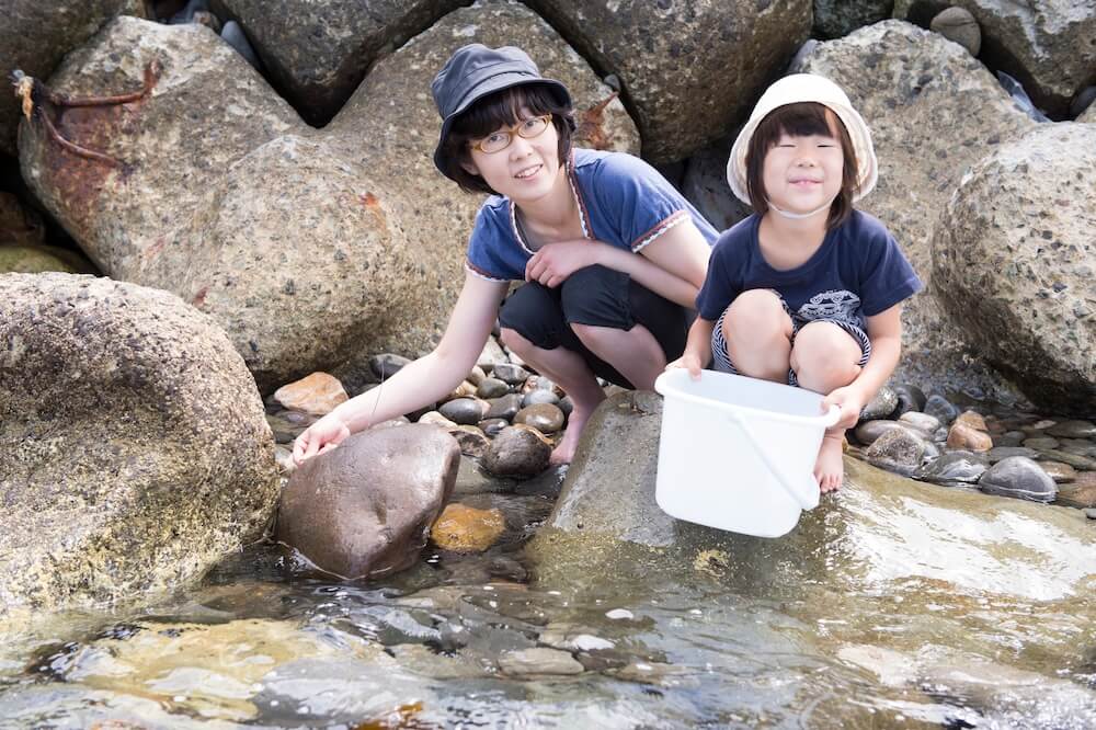 磯遊びをする母親と娘