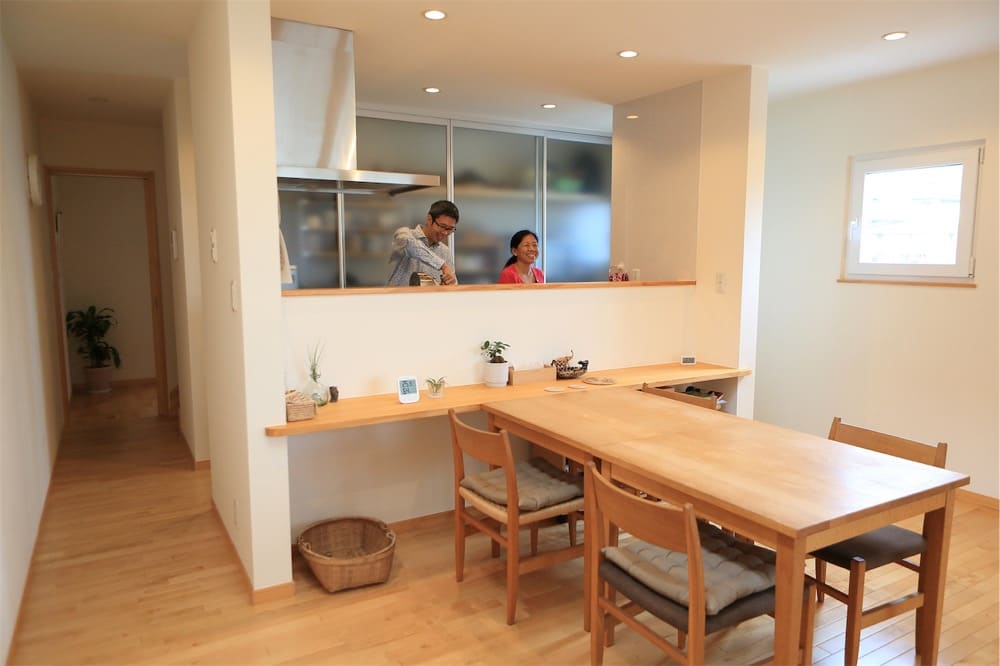 キッチンで家事をする髙橋さんとパートナー