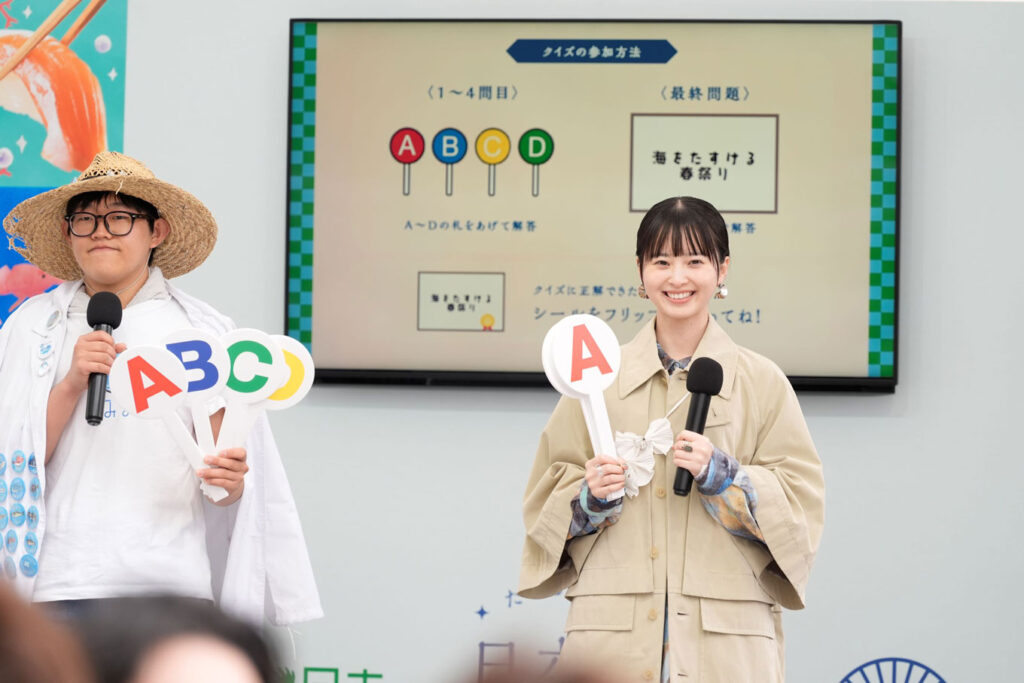 写真：クイズショーの様子（左側に猪原さん、右側に飯沼さん）