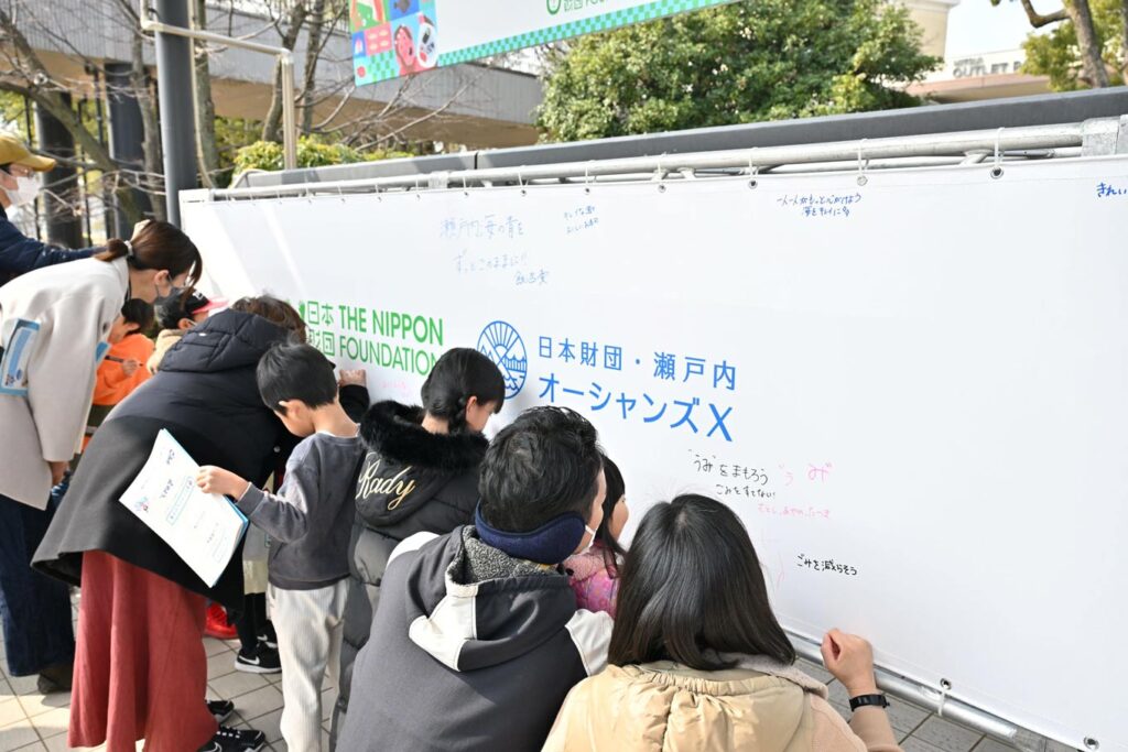 写真：メッセージフラッグにメッセージを書いている参加者たち