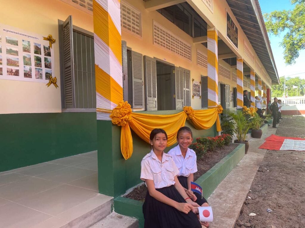 2024年に建設された新校舎の前で微笑む生徒たち（トボンクムン州チーモン小学校）