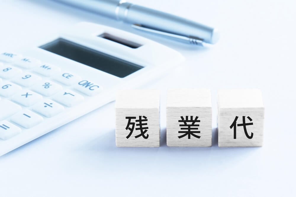 イメージ:電卓の横に「残業代」と書かれた積み木