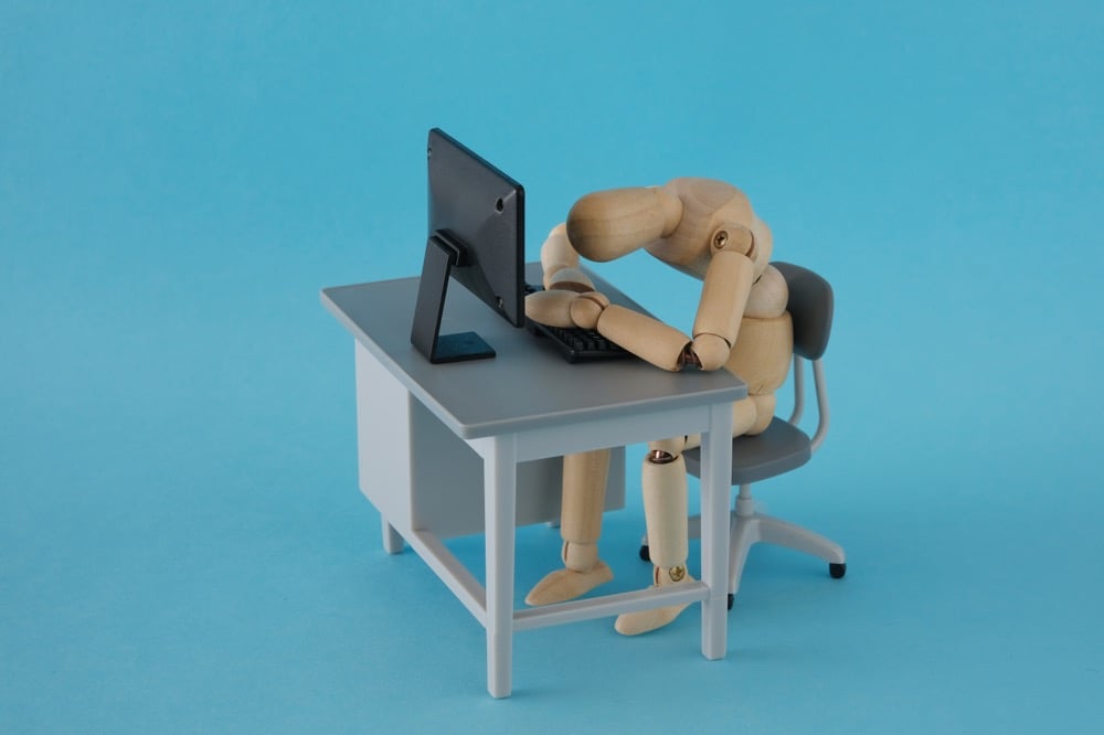 イメージ画像:PCの前でうつ伏せになる人