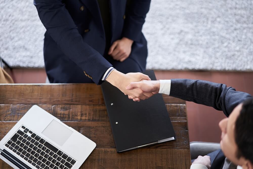 弁護士と握手をする依頼人