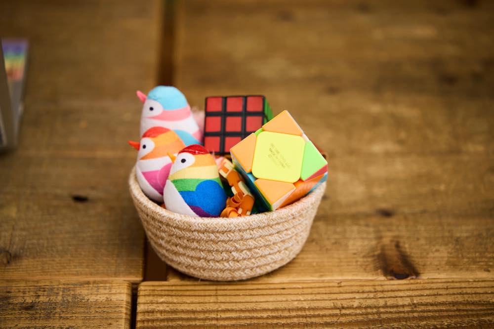 ルービックキューブや、鳥の形をしたぬいぐるみなど、フィジットトイが入れ物に入っている