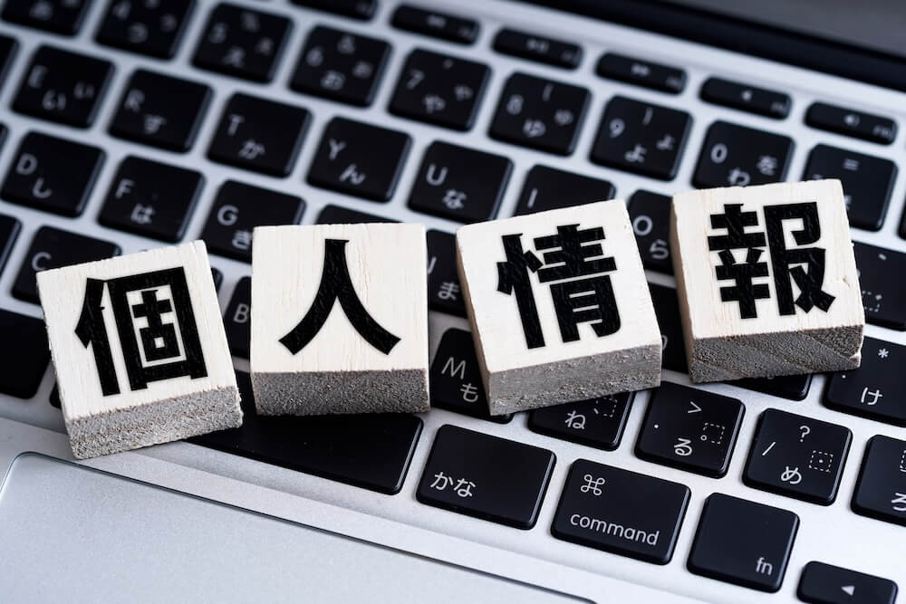 イメージ：
パソコンのキーボードの上に乗った「個人情報」の積み木