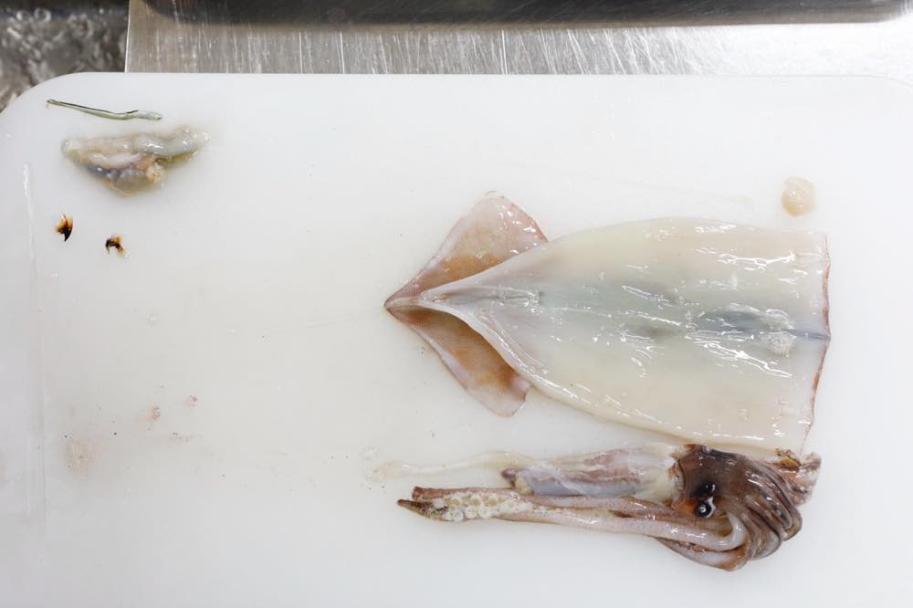 まな板の左上に、イカの食べられない部分、右下に食べられる部分が置かれている