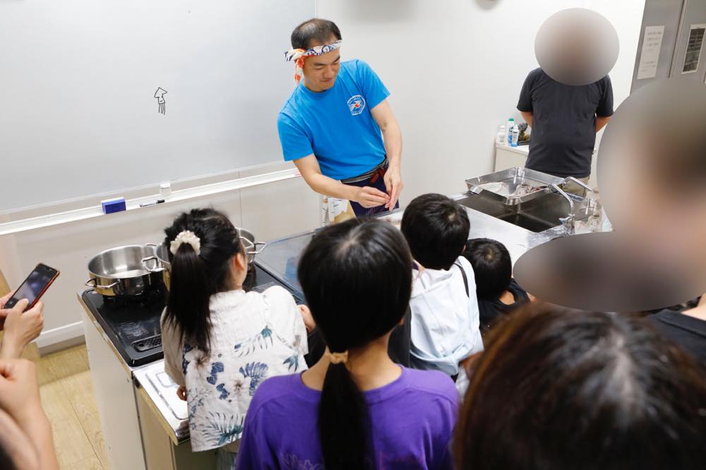 イカを解剖する早武さんの周りに子供たちが集まっている