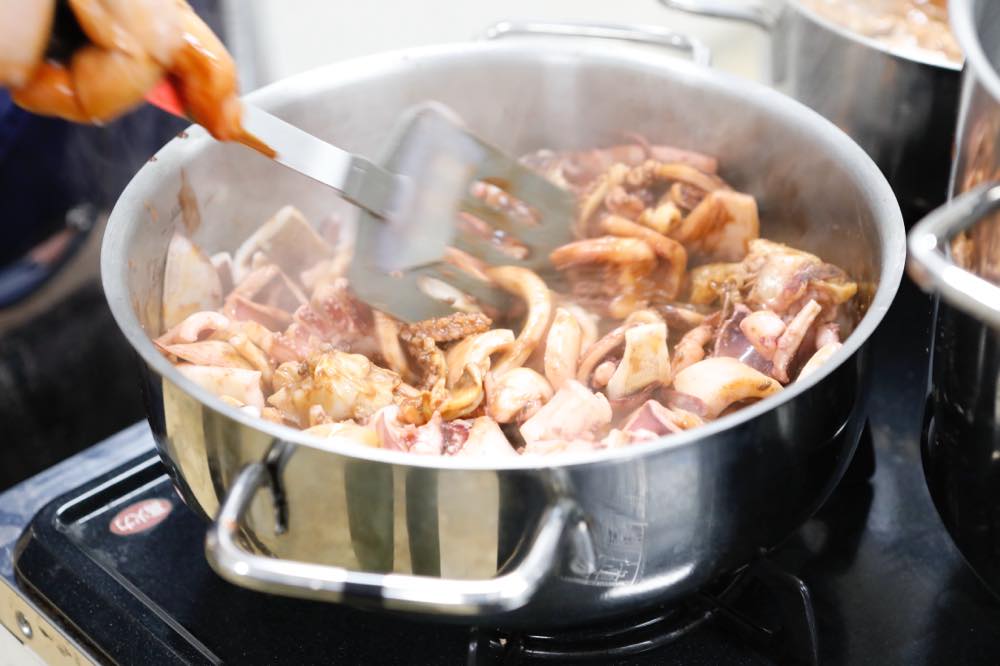 イカをフライ返しで炒めている様子