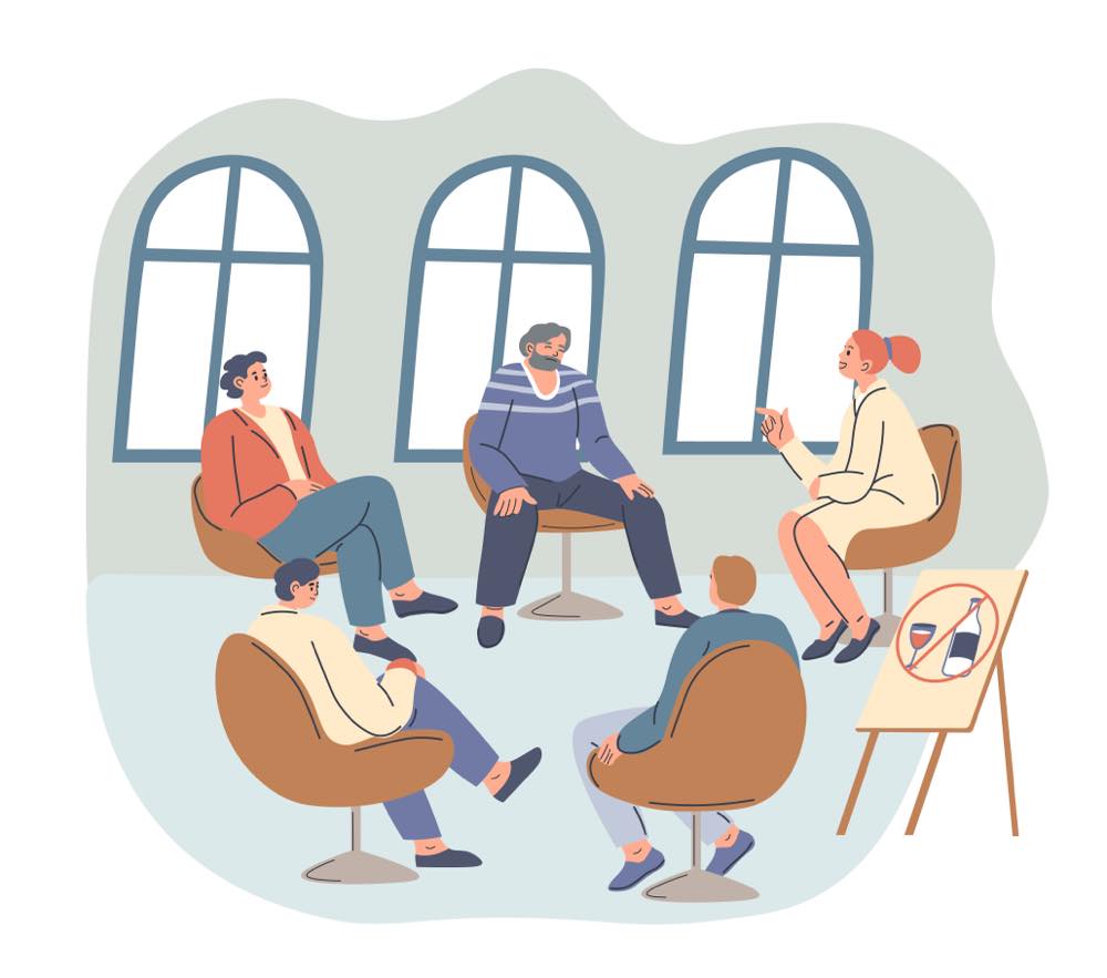 5人の人々が椅子に座り、円形に向かい合って会話をしている様子。