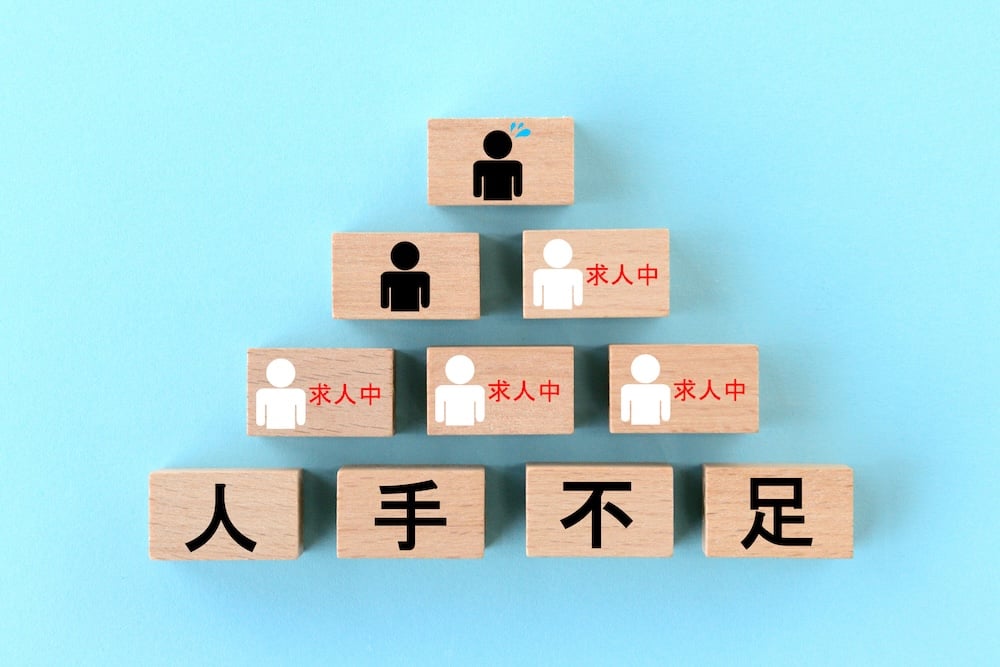 イメージ：人材不足の文字と人の輪郭が書かれた積み木