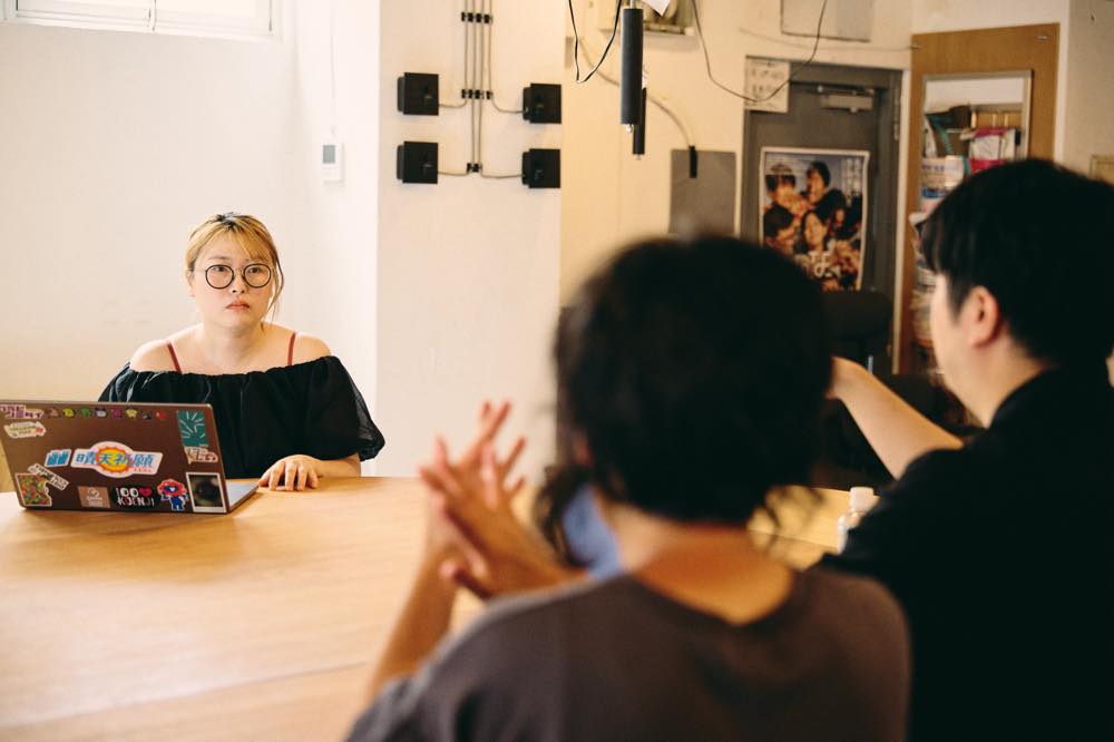 取材に応じる牧原さん。画面前方には、ライターと手話通訳士が写っている。